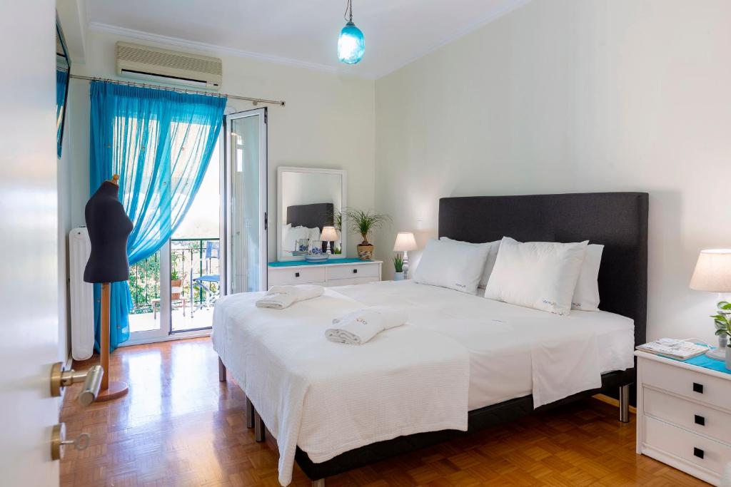 Un dormitorio con una gran cama blanca y una ventana en Casa Loula, en Corfú