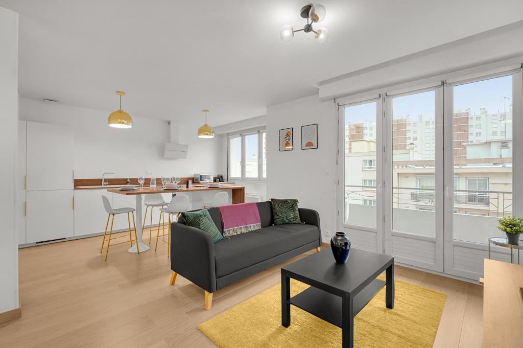ein Wohnzimmer mit einem Sofa und einem Tisch in der Unterkunft Le Synopsis - Joli T3 avec garage in Toulouse