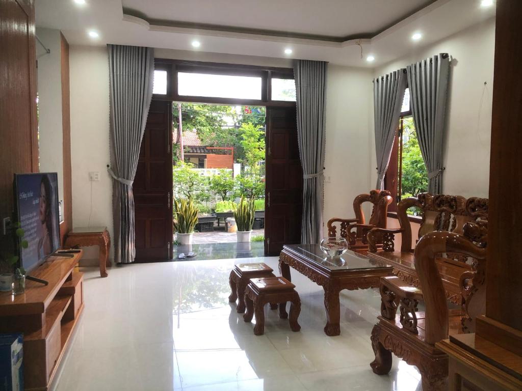 sala de estar con muebles de madera y ventana grande en Homestay Phương House, en Hoi An