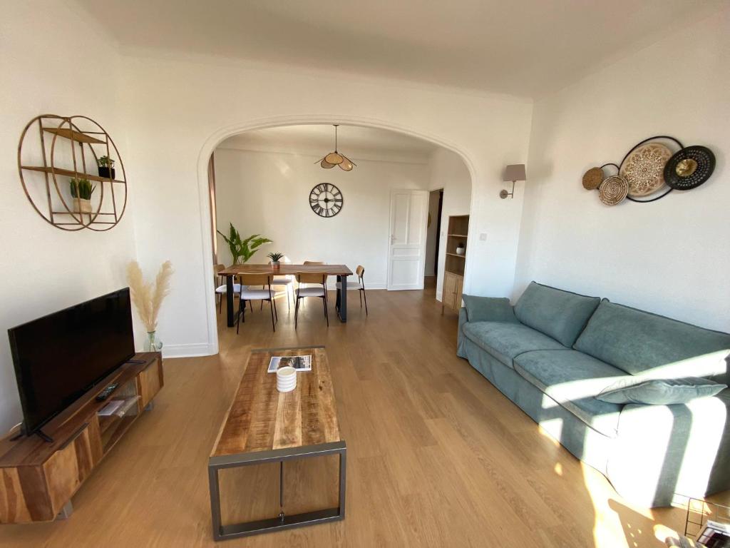 uma sala de estar com um sofá azul e uma mesa em 06AA1-Beau T2 500m de la plage et de la Croisette em Cannes