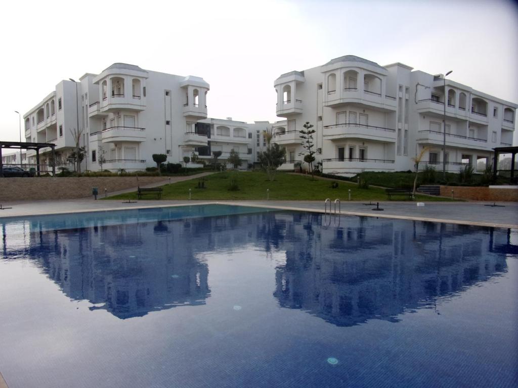 basen przed niektórymi budynkami apartamentowymi w obiekcie Bahia Golf Beach Bouznika appart w mieście Bouznika