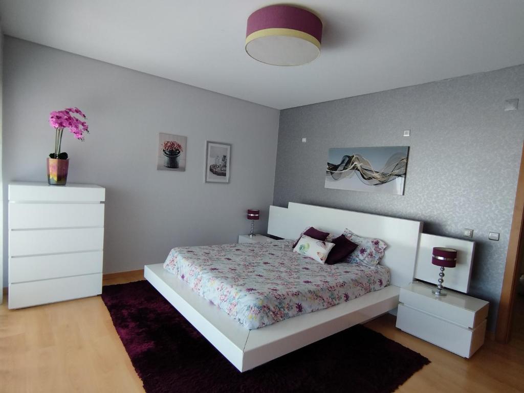 a bedroom with a white bed and a white dresser at Sunset Street Beach house in Lourinhã