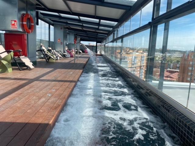 Ekilibrio Hotel & Apart-Suites في مدريد: حوض استحمام ساخن داخلي في مبنى به ماء