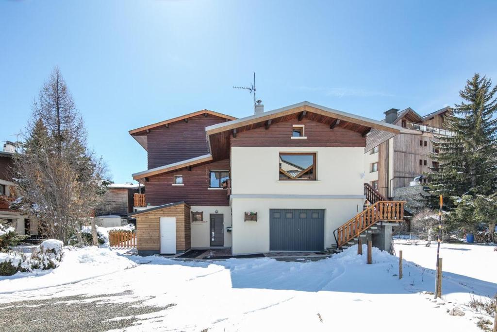 a house with a garage in the snow at Le Chalet in Les Deux Alpes