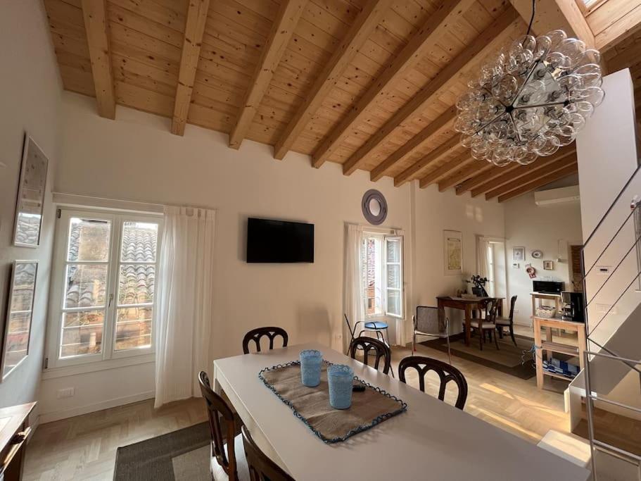 a kitchen and dining room with a table and a chandelier at La Piccola Casa al Lago - Intera casa con 3 camere e 2 box in Salò
