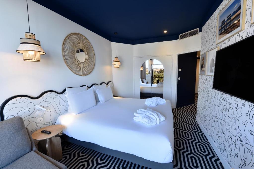 a bedroom with a large white bed and a couch at Albert 1er in Nice