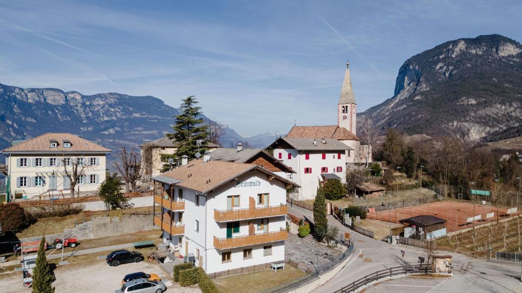 una pequeña ciudad en las montañas con una iglesia en Grünwald en Salorno