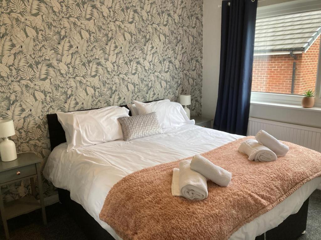 a bedroom with a bed with two towels on it at Modern cosy home sleeps 6 with parking nr Preston in Leyland