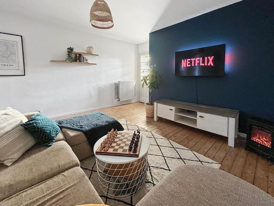 een woonkamer met een bank en een tv met een Netflix-bord bij Cozy Antwerp - Zurenborg Skyline FREE PARKING in Antwerpen