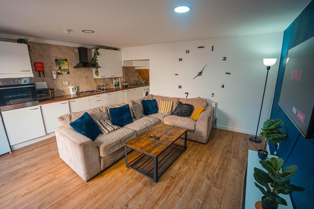 a living room with a couch and a table at Private and Spacious 2 Bedroom House - Free Parking! in Cardiff