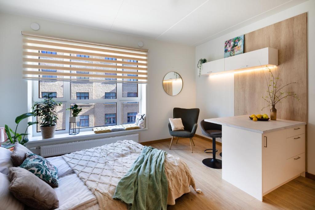 a bedroom with a bed and a desk and a window at Leonardo Studio Apartments In City Center in Rīga