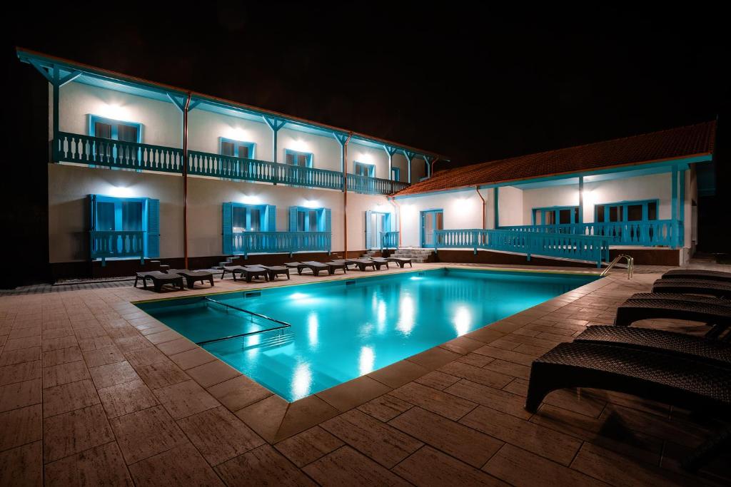 una piscina frente a un edificio por la noche en Vila Mavis-cazare cu piscina incalzita 1 mai-30 sept, en Mahmudia