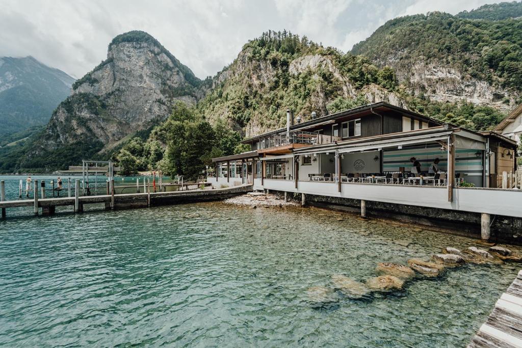 a building next to a body of water with mountains at Beachhouse Isleten in Bauen