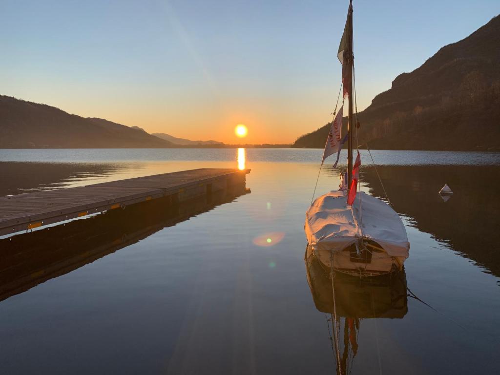 a boat sitting on the water near a dock at COSY LITTLE HOME in Mergozzo