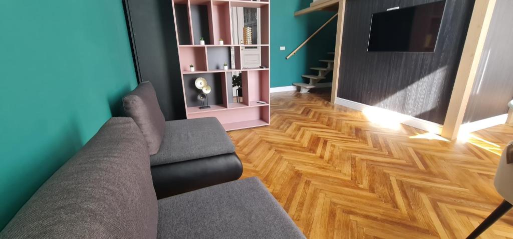 a living room with a couch and a wooden floor at Extravagant Apartments km0 PrimariaArad in Arad