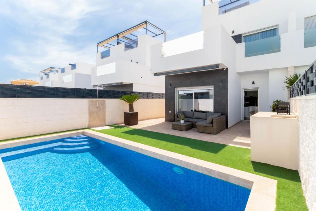 una casa con piscina frente a ella en Villa Marabu Lagoon en Ciudad Quesada