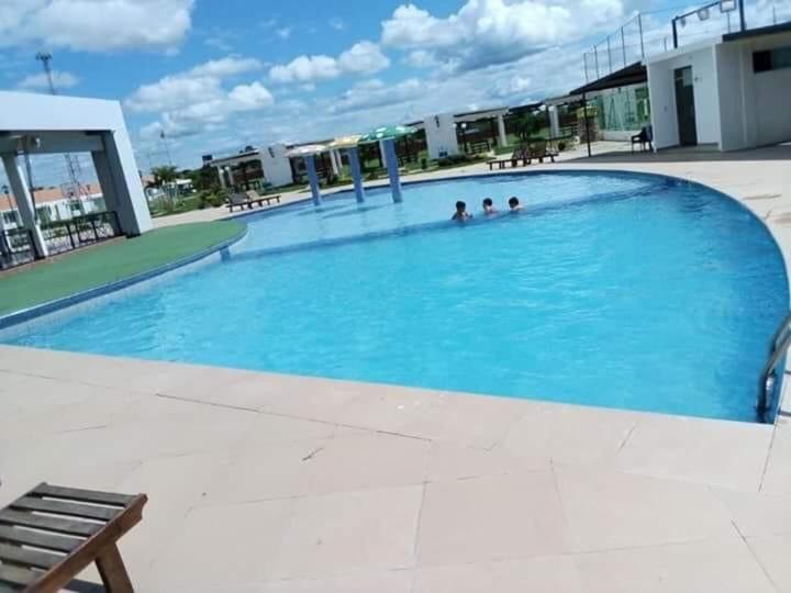 a large blue swimming pool with people in it at Casa en condominio el dorado in Trinidad