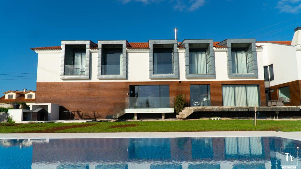 uma casa com uma piscina em frente em Quinta das Donas em Anadia