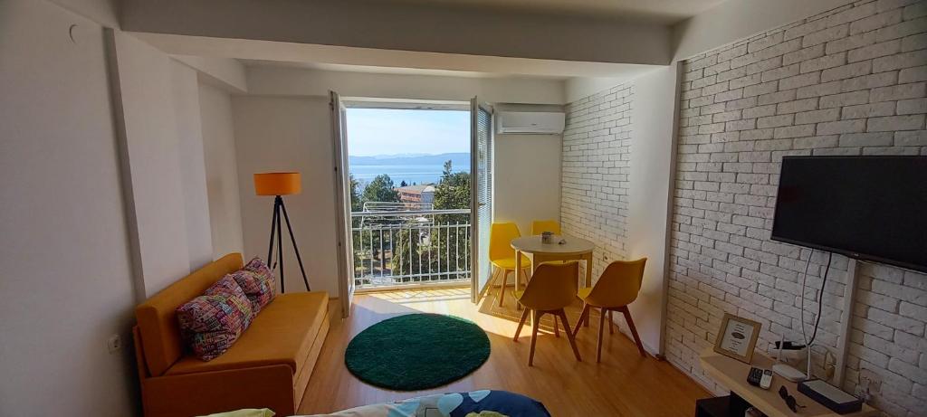 een woonkamer met een bank, een tafel en een raam bij Krkulj Apartments in Ohrid