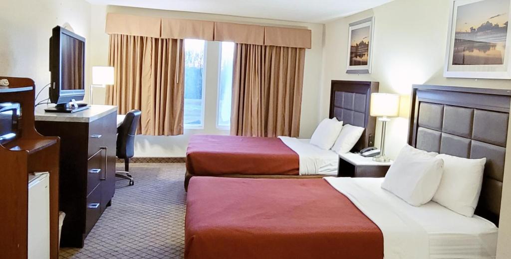Habitación de hotel con 2 camas y escritorio en Home Inn & Suites, en Montgomery