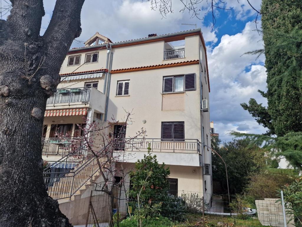 ein Apartmenthaus mit einem Balkon und einem Baum in der Unterkunft Apartments Katarina - New renovated in Rovinj