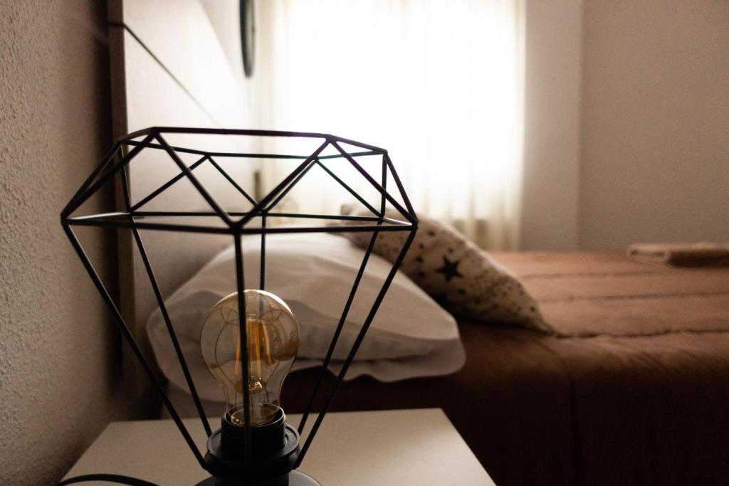 a lamp on a table in a room with a bed at El Refugio de Eliseo in Haro