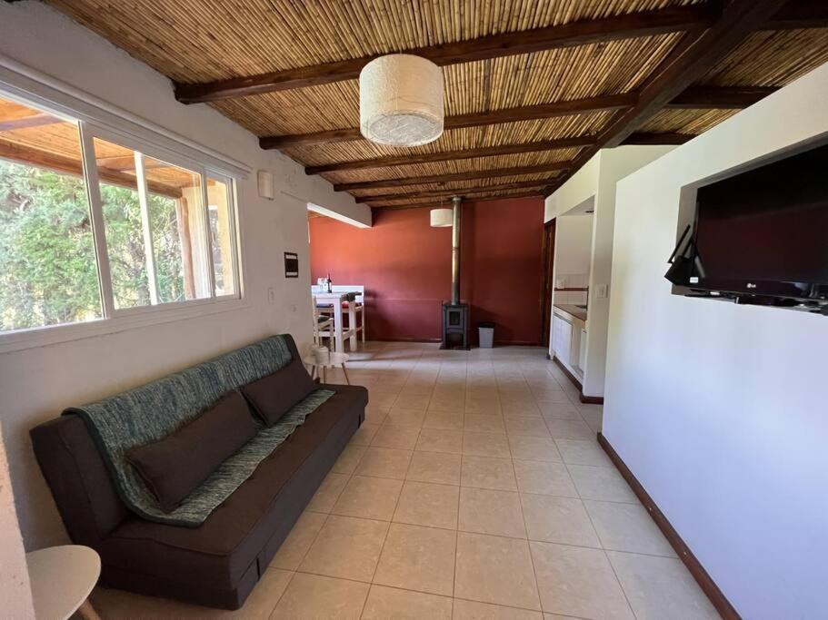 a living room with a couch and a flat screen tv at Cabaña Chacras de Caro in Chacras de Coria