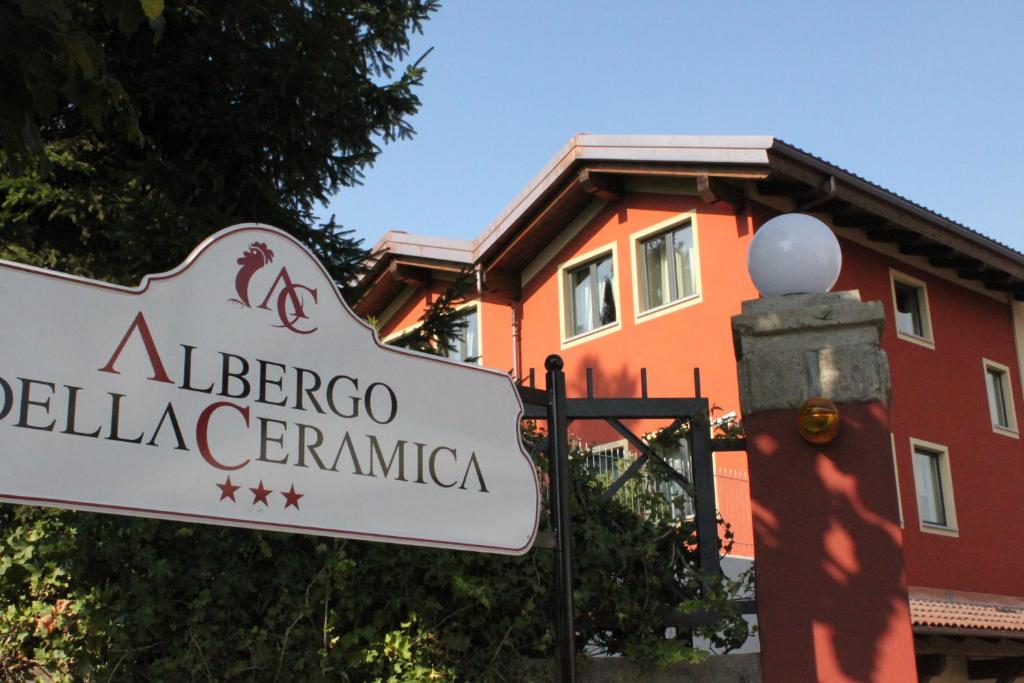 um sinal para um albergo pellegrinole generale à frente em Albergo della Ceramica em Villanova Mondovì