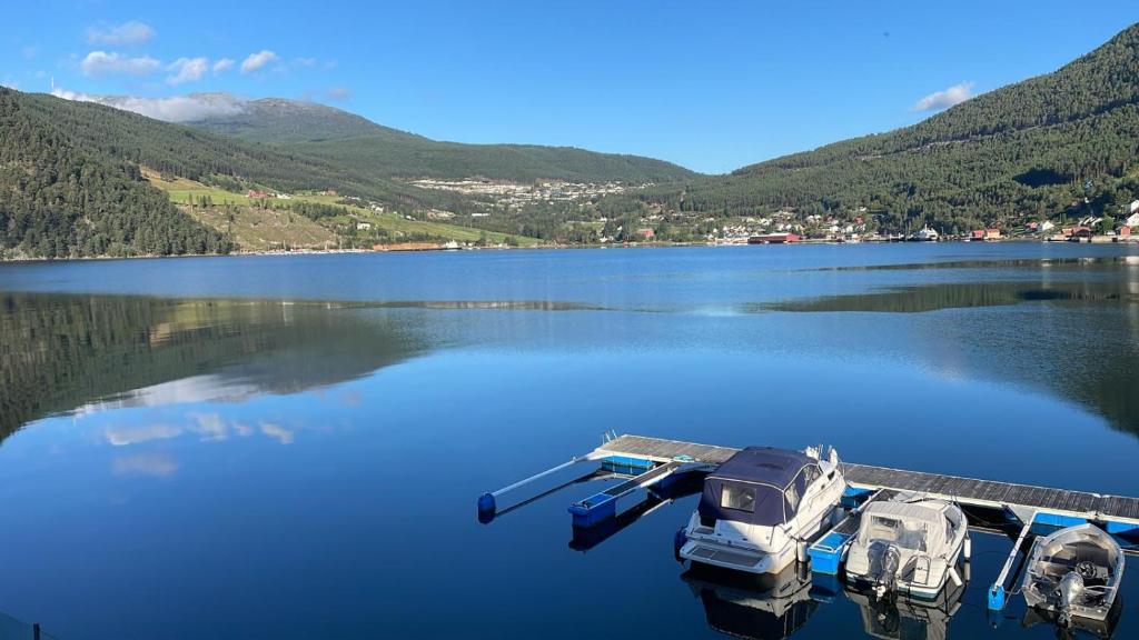 Due barche sono parcheggiate su un molo su un lago di Nedre Amla Fjord Apartment a Kaupanger