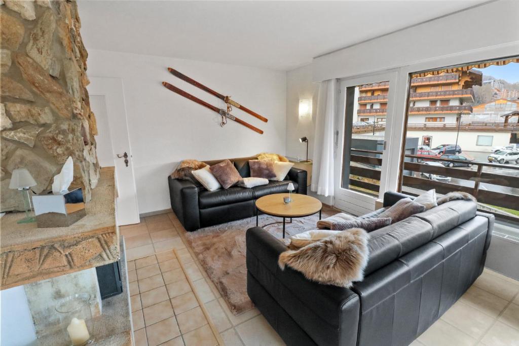 a living room with two couches and a fireplace at Joli appartement en plein centre in Nendaz