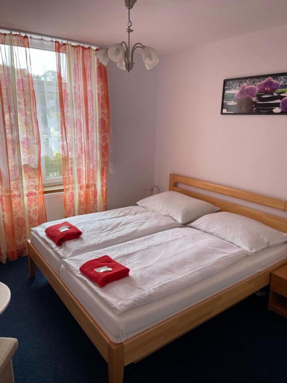 Un dormitorio con una cama con toallas rojas. en Hotel V Pivovaře Davle, en Davle