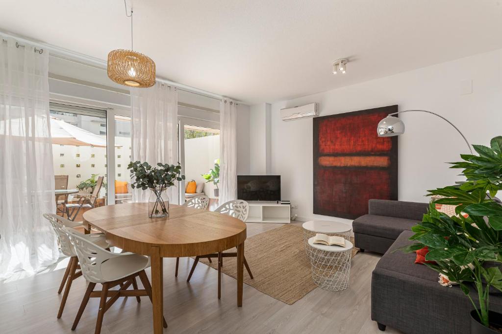 een woonkamer met een tafel en een bank bij BNBHolder Terrace, Pool & Gym LAS TABLAS in Madrid