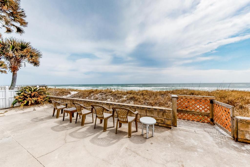 una fila de sillas y mesas en la playa en O'Grady's Full Sunset, en Panama City Beach