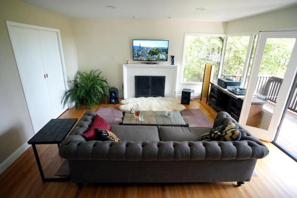 a living room with a brown couch and a tv at North Berkeley Home in Berkeley