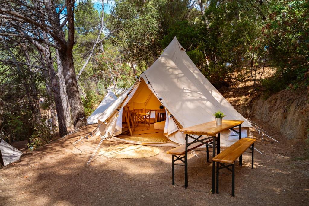 uma tenda com uma mesa e cadeiras em frente em Kampaoh Tossa de Mar em Tossa de Mar