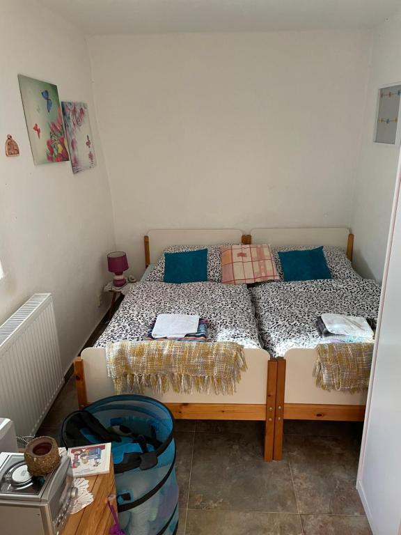 a small bedroom with a bed with blue pillows at Chalupa Kalamajka in Horní Štěpánov