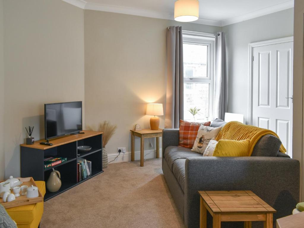 a living room with a couch and a tv at Russell Retreat in Skipton