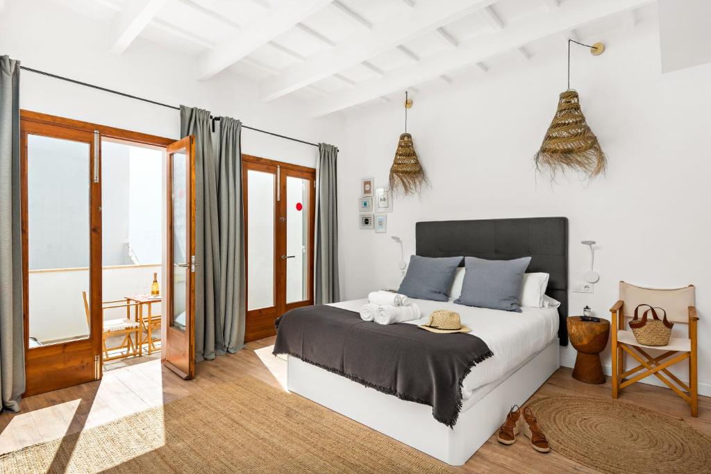 ein Schlafzimmer mit einem großen Bett und einem Balkon in der Unterkunft Hotel Boutique Ses 5 Claus in Ciutadella