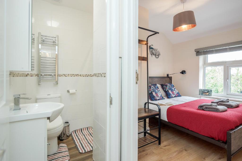 uma casa de banho com uma cama e um lavatório num quarto em Dwellers Delight Living 3 Bed House 2 Bathroom with Wifi & Parking in Prime Location of London Chingford Enfield Area em Chingford