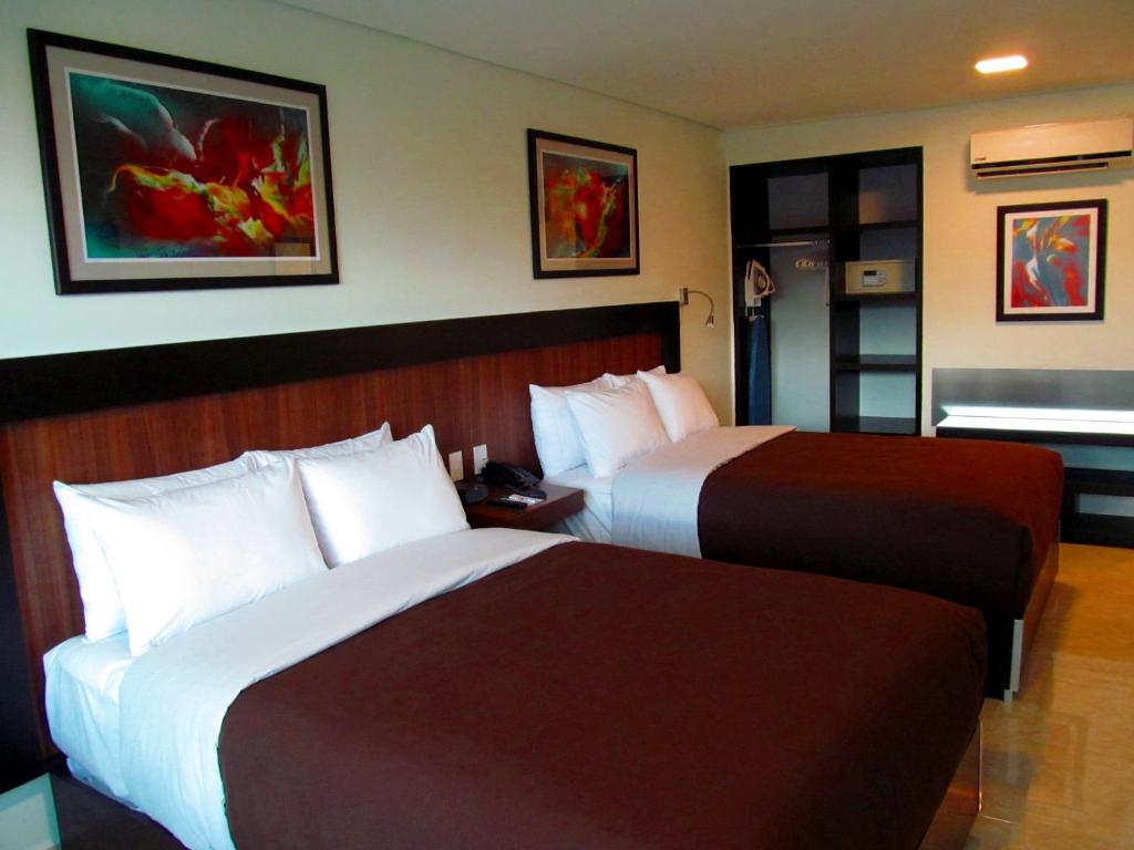 Una cama o camas en una habitación de Hotel & Suites PF