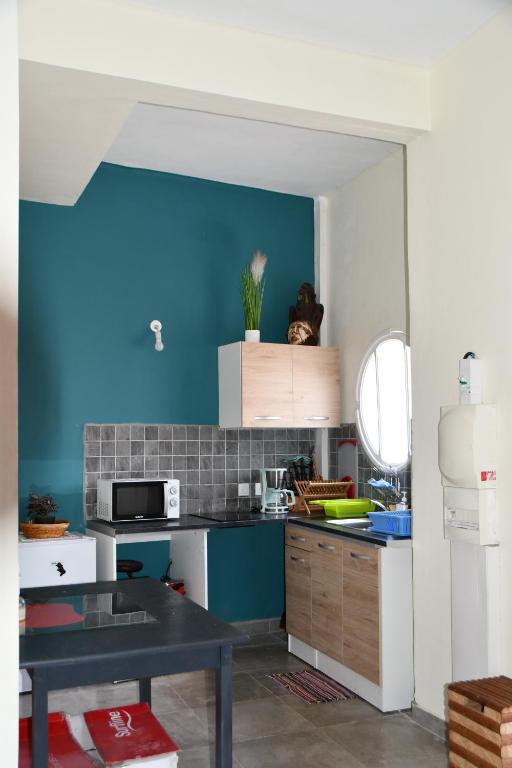 cocina con paredes azules y mesa negra en Arnaud-Michel, en Pointe-à-Pitre