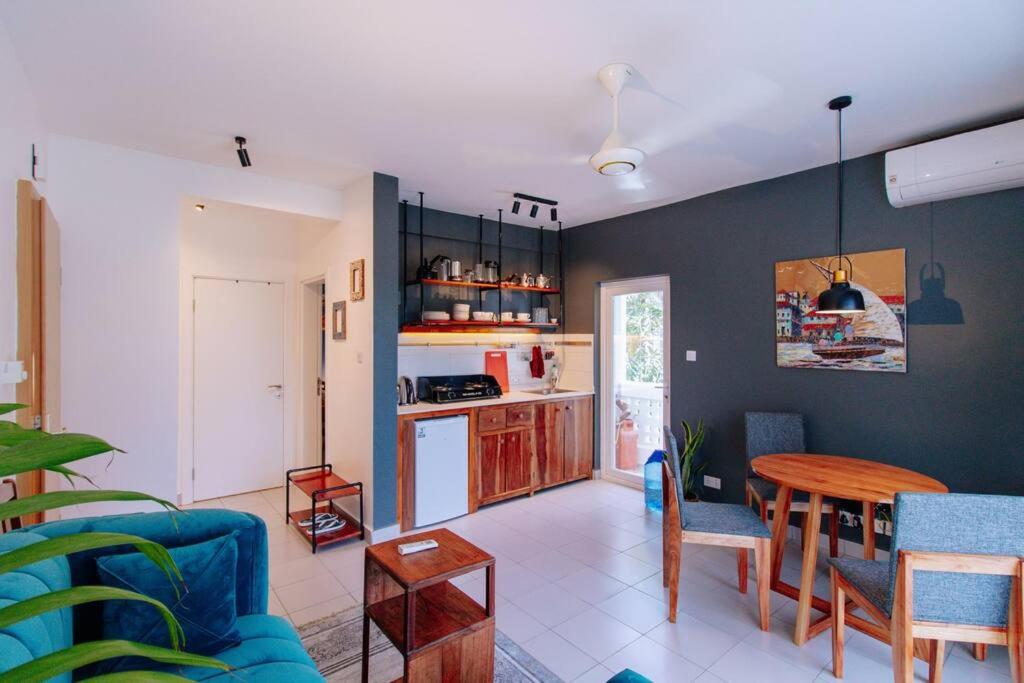 a living room with a table and a kitchen at Amani Cottage in Dambani