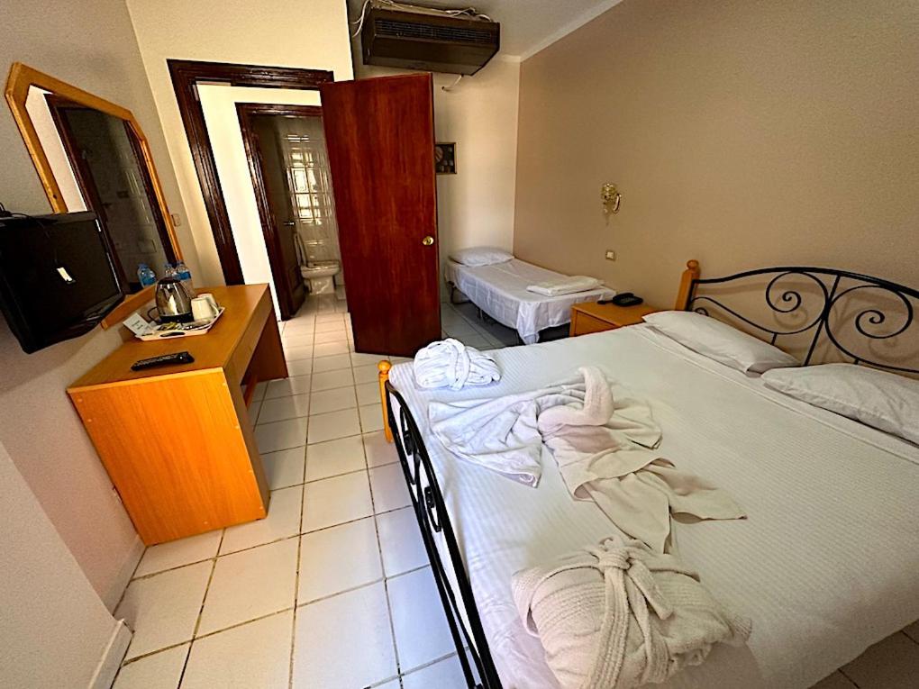 Postel nebo postele na pokoji v ubytování Gaddis Hotel, Suites and Apartments