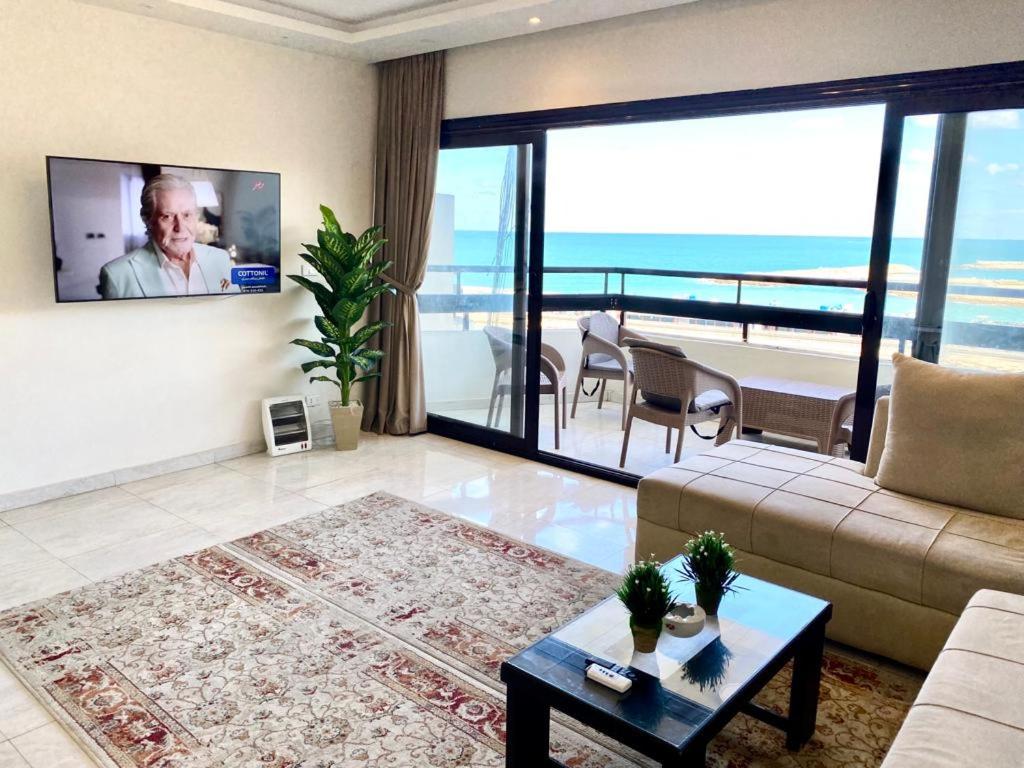 ein Wohnzimmer mit einem Sofa und Meerblick in der Unterkunft Alexandria Luxury Apartments Gleem 2 Direct Sea View in Alexandria
