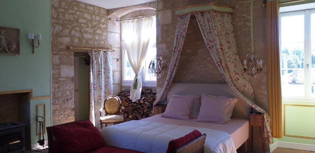 a bedroom with a bed with a canopy and a window at Chambre Renaissance au Château de Champagne-Mouton in Champagne-Mouton