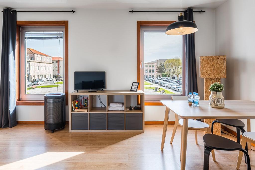 a living room with a table and a television at Coreto Apartment in Vila do Conde