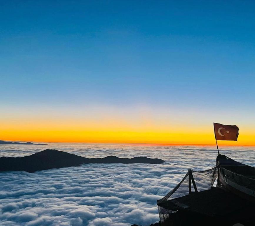 una bandera sobre las nubes con una puesta de sol en Huser Bungalov, en Rize