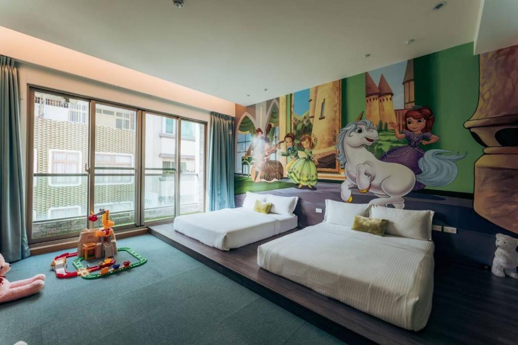 台南的住宿－台南趣游玩設計小宿，一间卧室配有两张床和一幅独角兽壁画