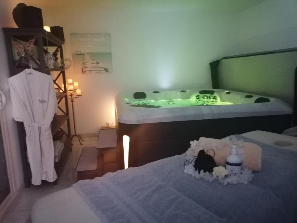 een kamer met een ligbad en een bed met een bed van zes bij L'INSTANT ZEN NATURISTE ONLY ADULTE in Fresnay-en-Retz