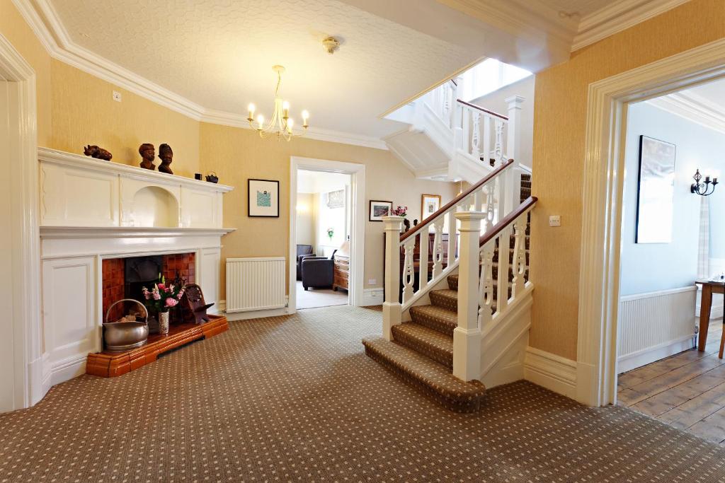 a living room with a staircase and a fireplace at Camberley House in Sheringham